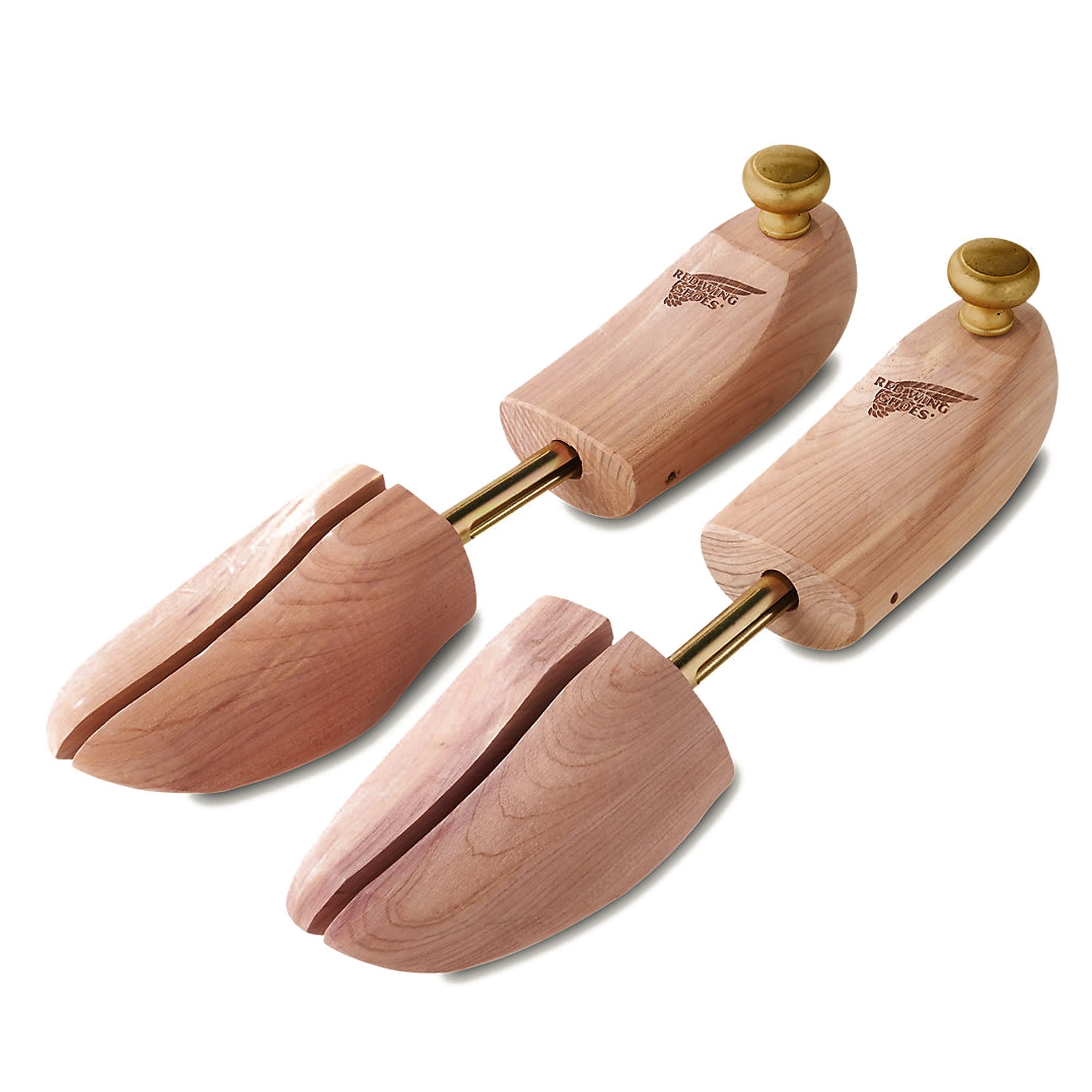 A pair of light brown cedar wood shoe trees on a white background.
