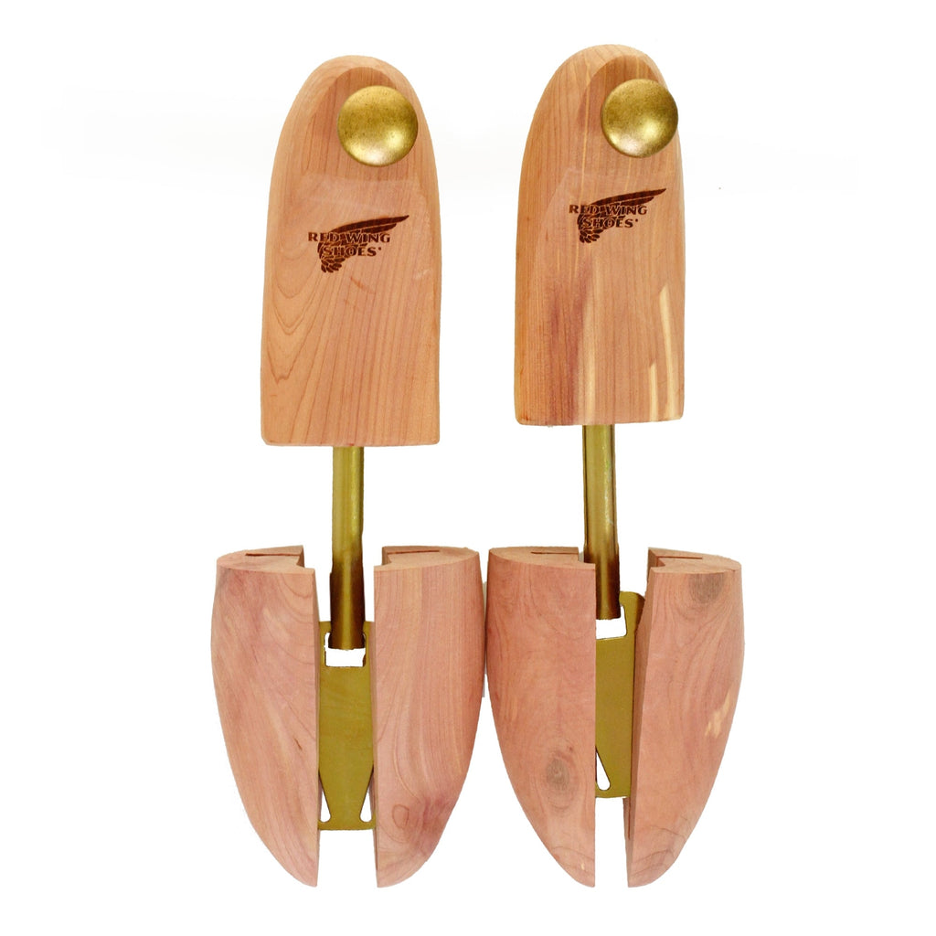 A pair of cedar wood shoe trees featuring the Red Wing Shoes logo and brass knobs.