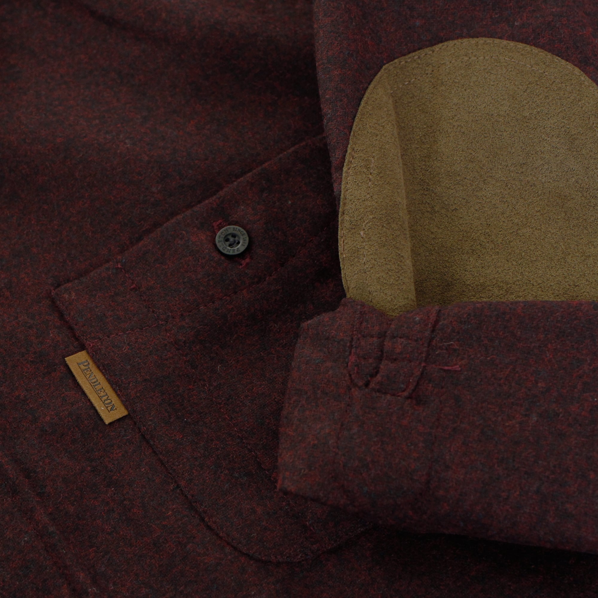 A close-up of the shirt's dark red fabric, highlighting a brown elbow patch and button details.