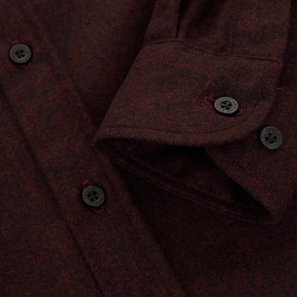 A detailed close-up of the dark red shirt's cuffs with visible buttons and stitching.