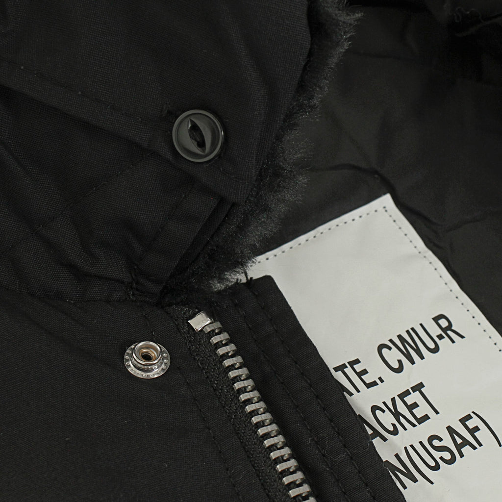 A close-up of the black bomber jacket's zipper, button, and inner label.