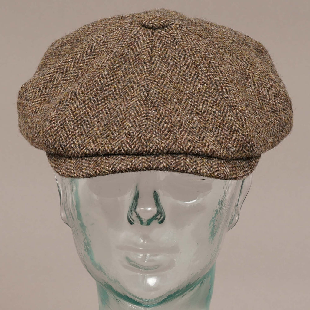 Front view of a brown herringbone flat cap on a mannequin head.