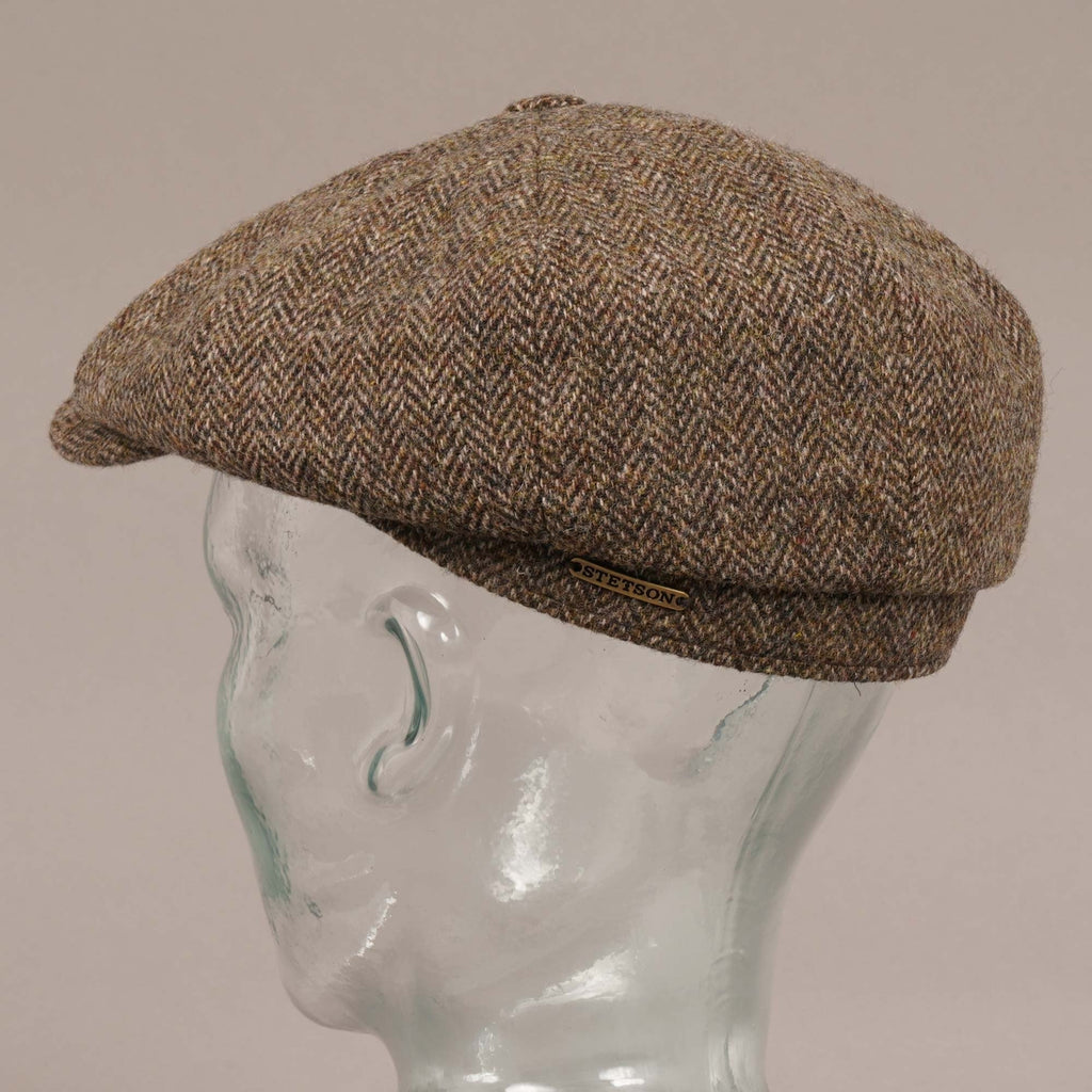 Side profile of a brown herringbone flat cap with a Stetson logo on a mannequin head.