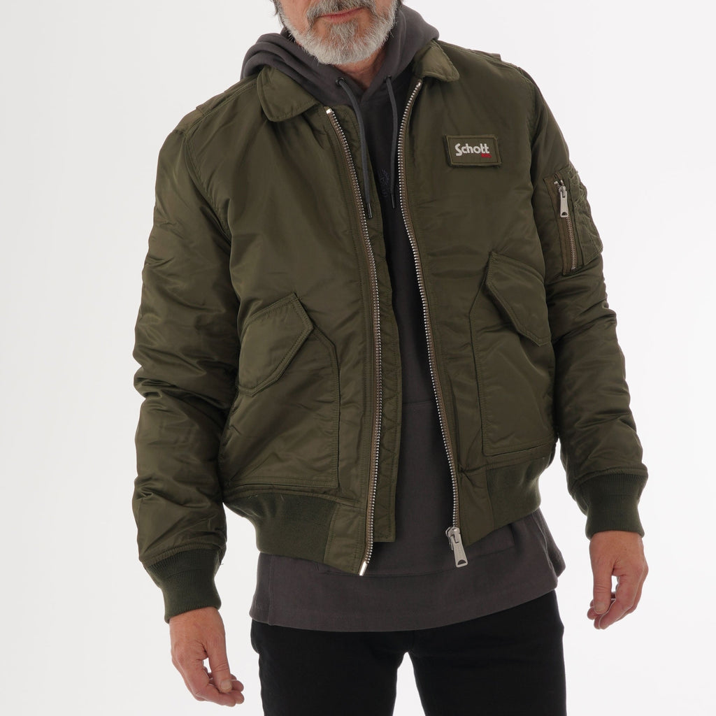 Front view of a man wearing a khaki bomber jacket over a grey hoodie.