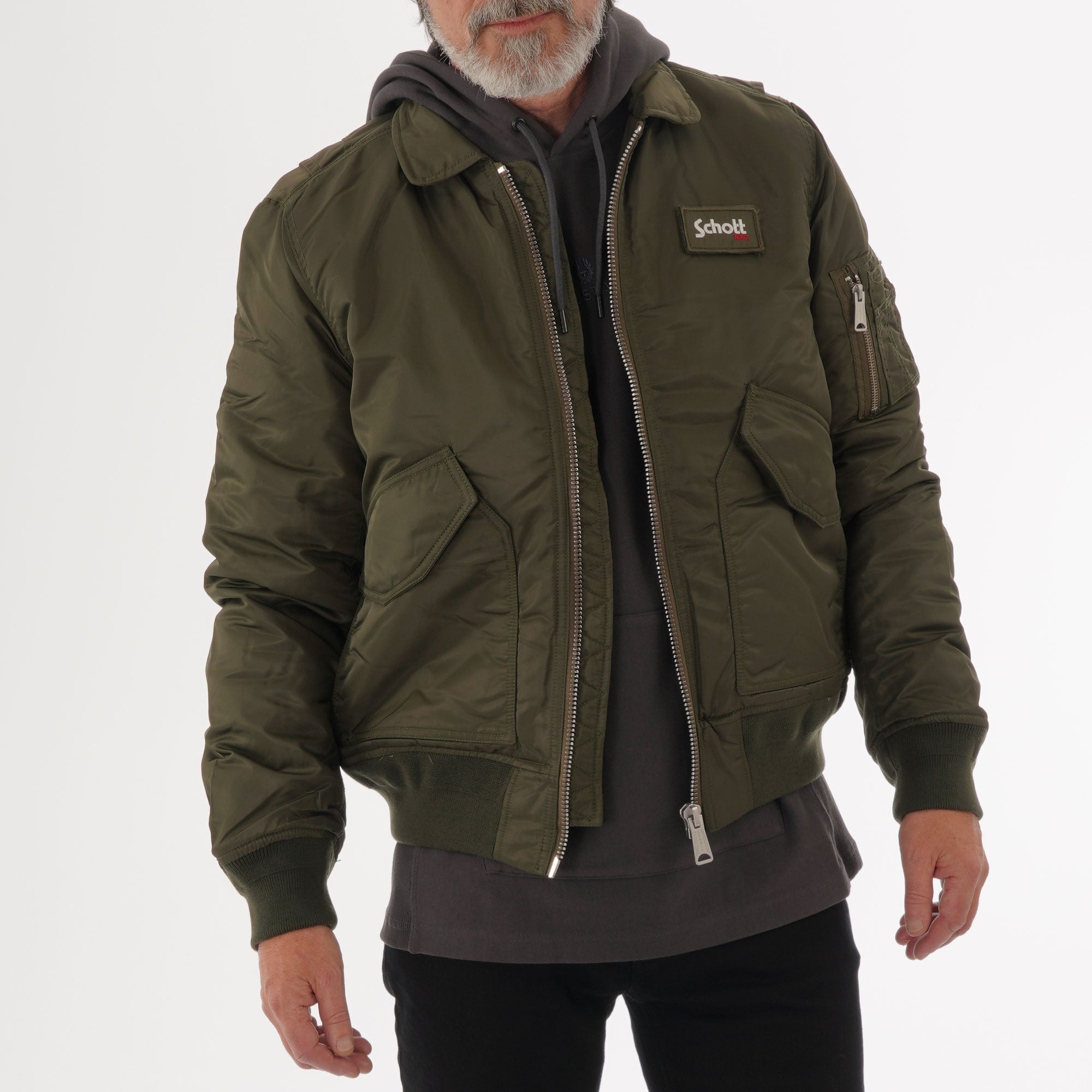 Front view of a man wearing a khaki bomber jacket over a grey hoodie.