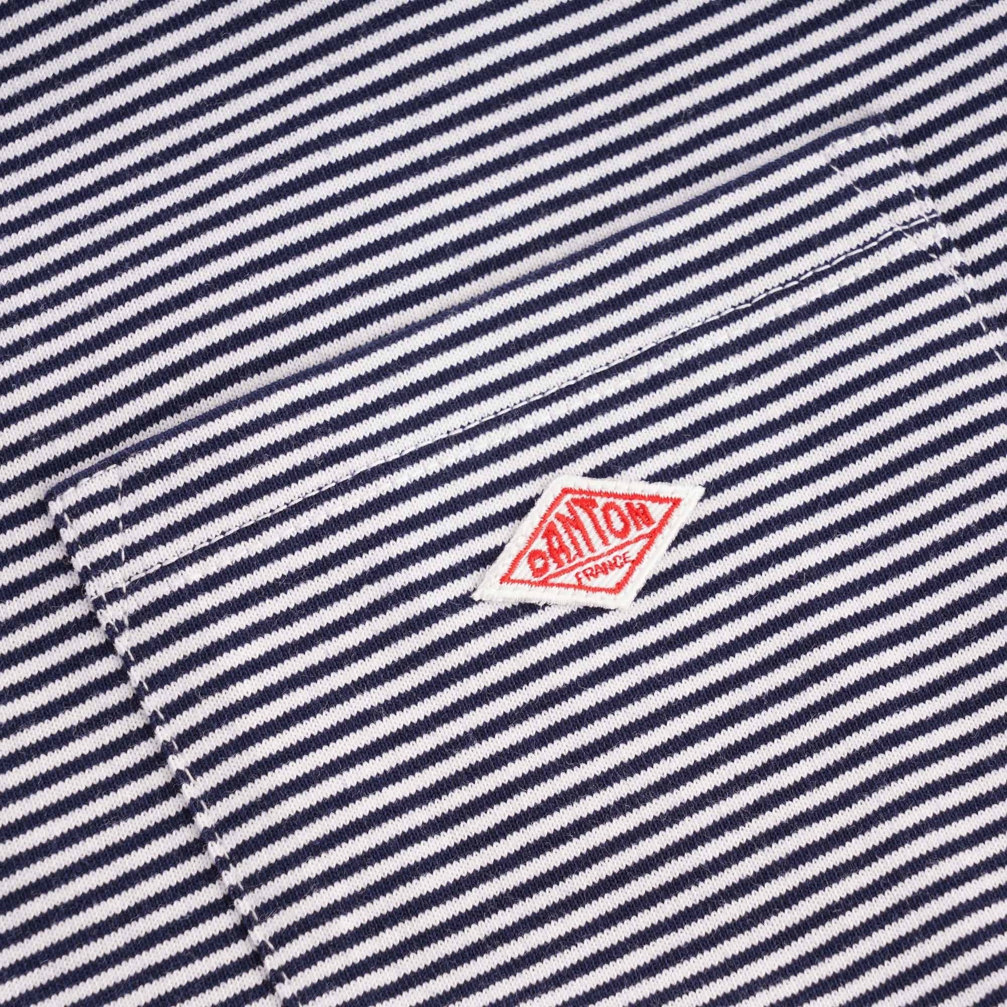 Detail of the red Danone logo on the striped fabric of the T-shirt's chest pocket.