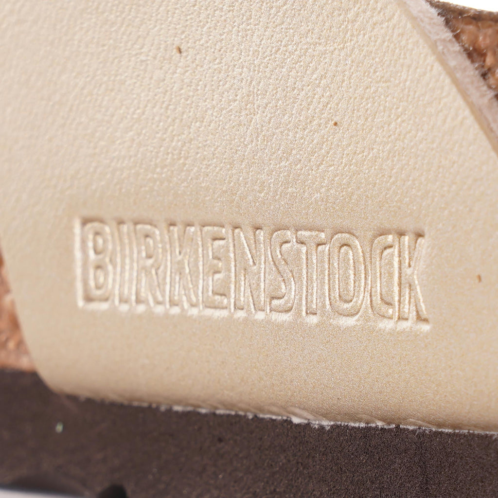 A close-up of the Birkenstock logo embossed on the cork footbed of a sandal.