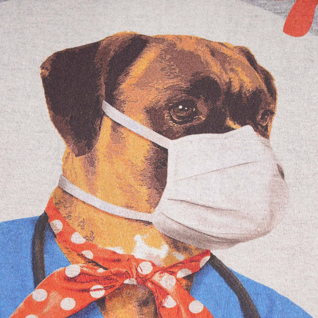 Close-up of a dog in a medical uniform with a mask and a red polka-dot scarf.