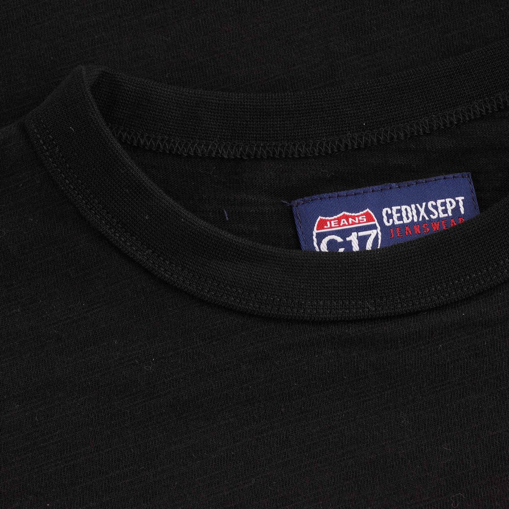 A close up of the C17 Jeans neck label of a black t-shirt.