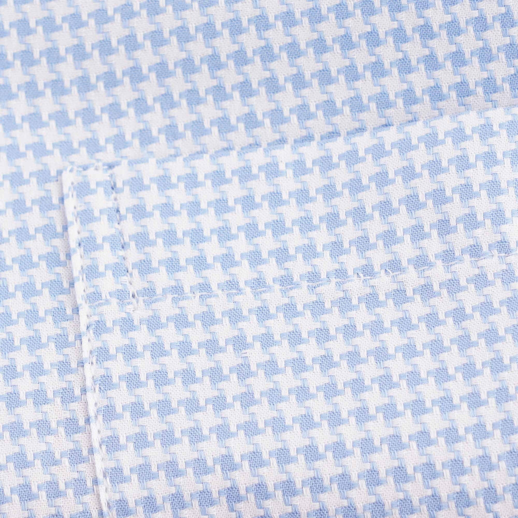 Detailed view of the light blue and white houndstooth fabric pattern on the shirt.