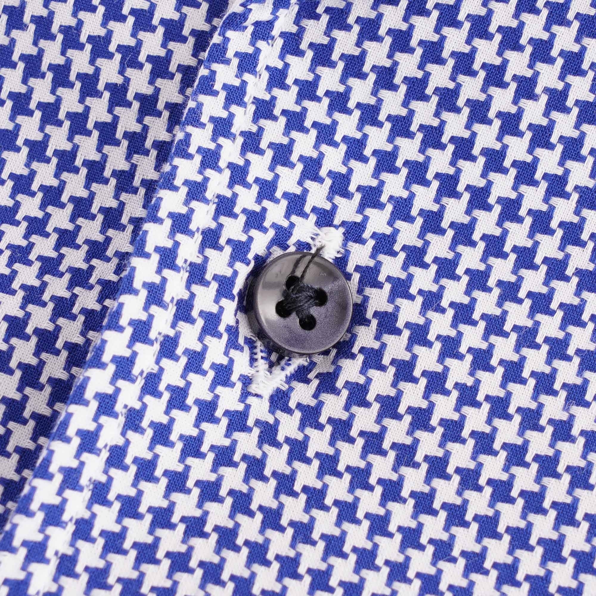Close-up of a dark button on the blue and white houndstooth patterned shirt.