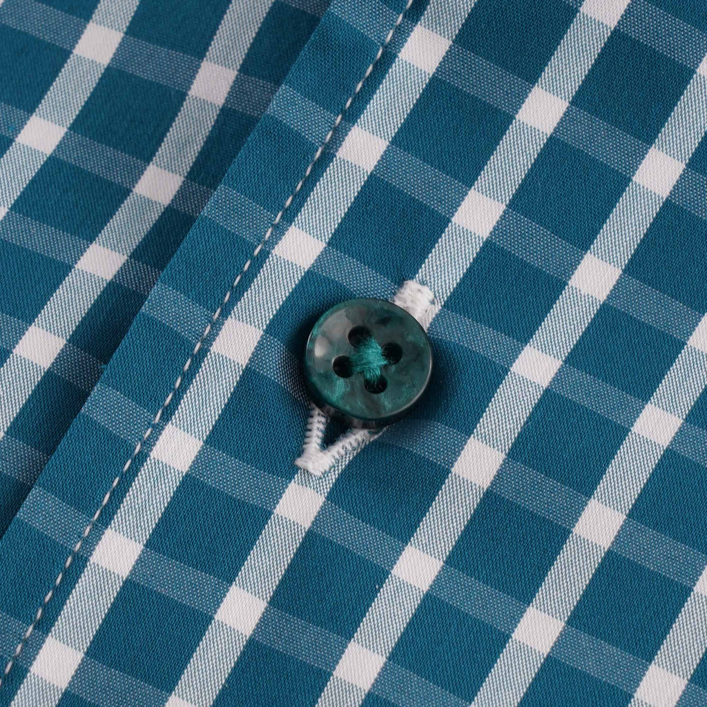 Close-up of a blue-green button on the checked shirt.