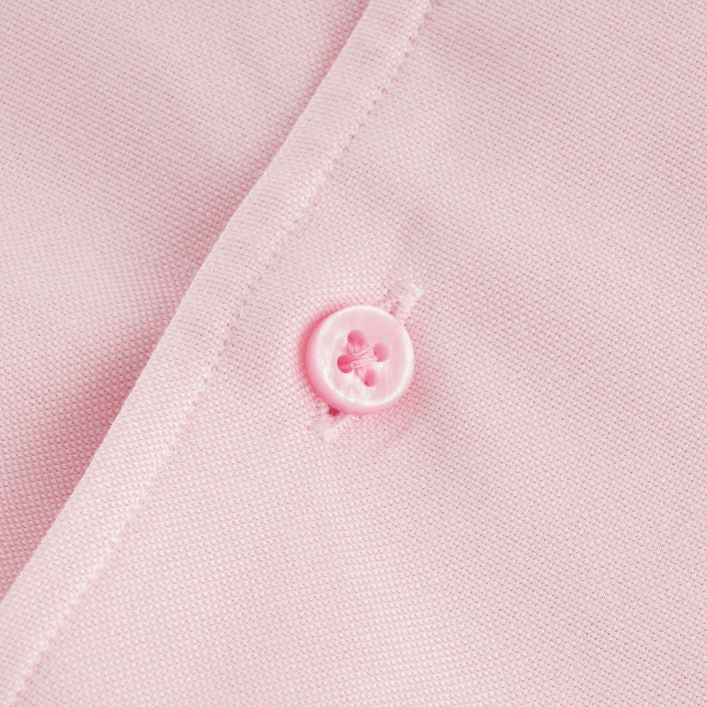 Close-up of a pink button on the shirt's placket. 