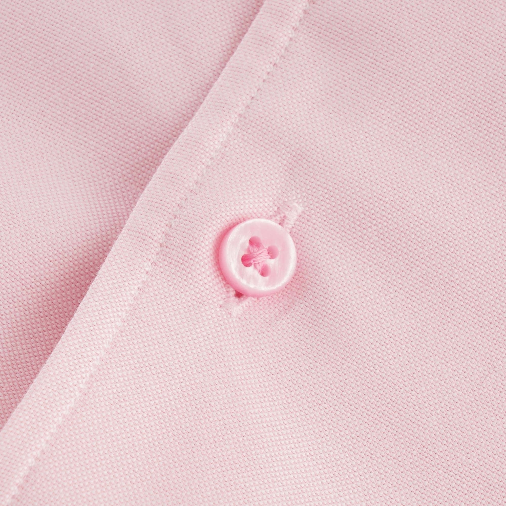 Close-up of a pink button on the shirt's placket. 