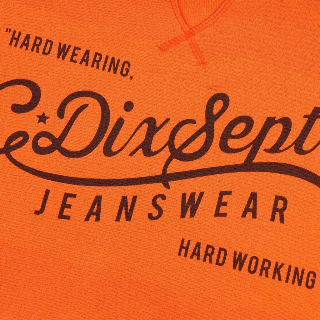 Close-up of the 'C17 Dixsept Jeanswear' logo on the orange hoodie.