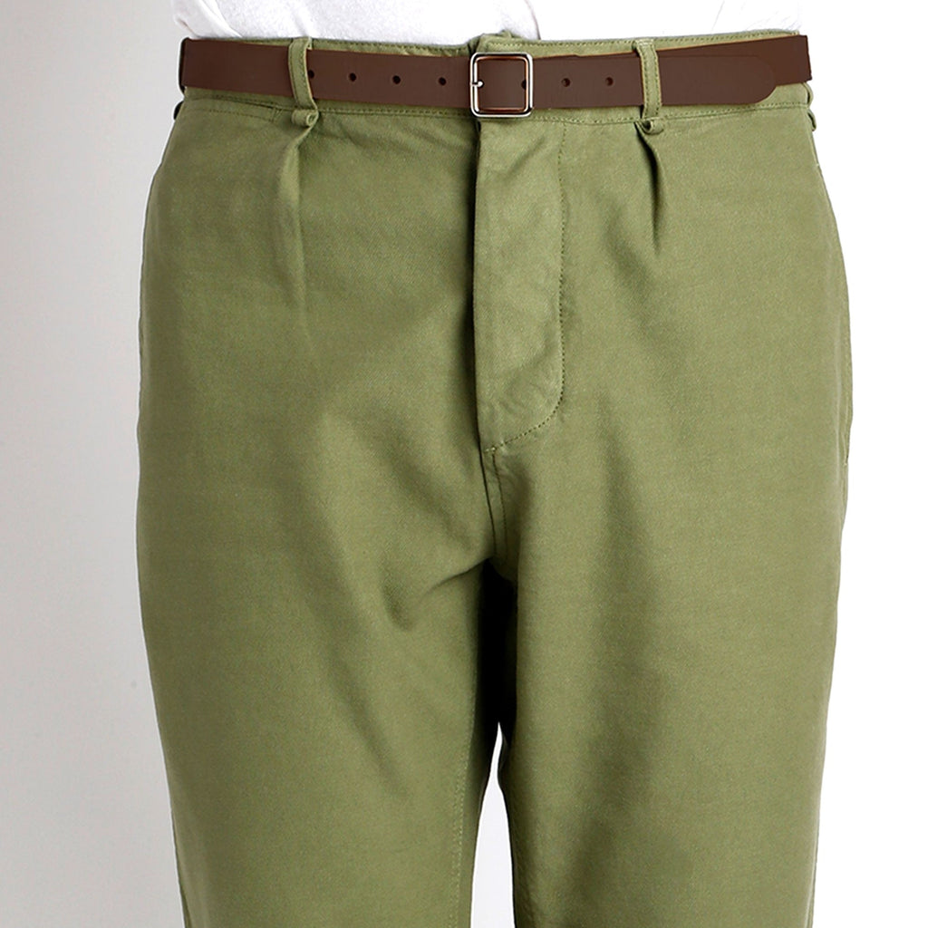 Close-up of the front of sage green trousers with a brown belt.
