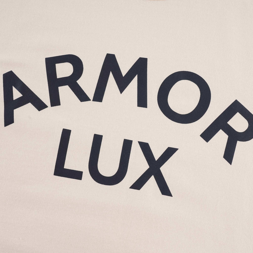 A close-up of the 'ARMOR LUX' navy print on the cream T-shirt.