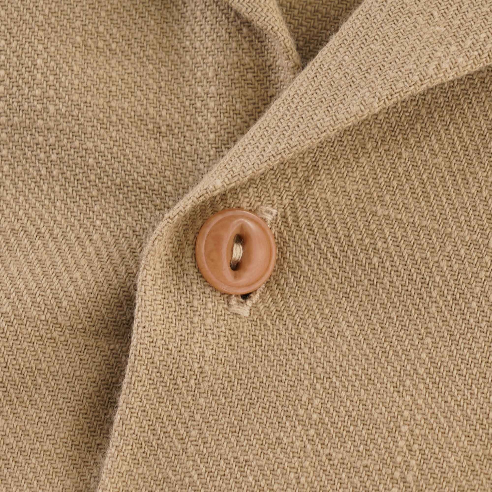 Close-up of a brown button and the textured fabric of the shirt.