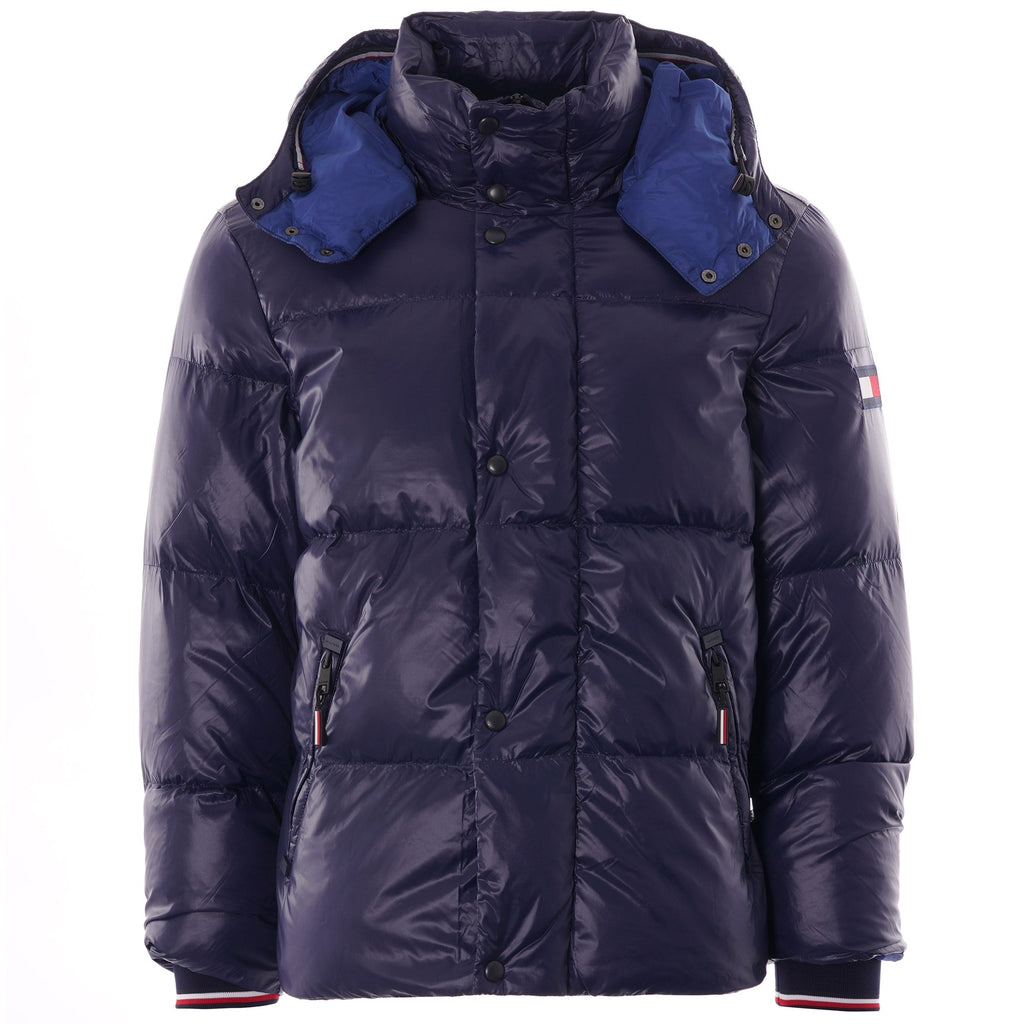 A navy blue puffer jacket with a hood, blue lining, and a small flag logo on the arm.
