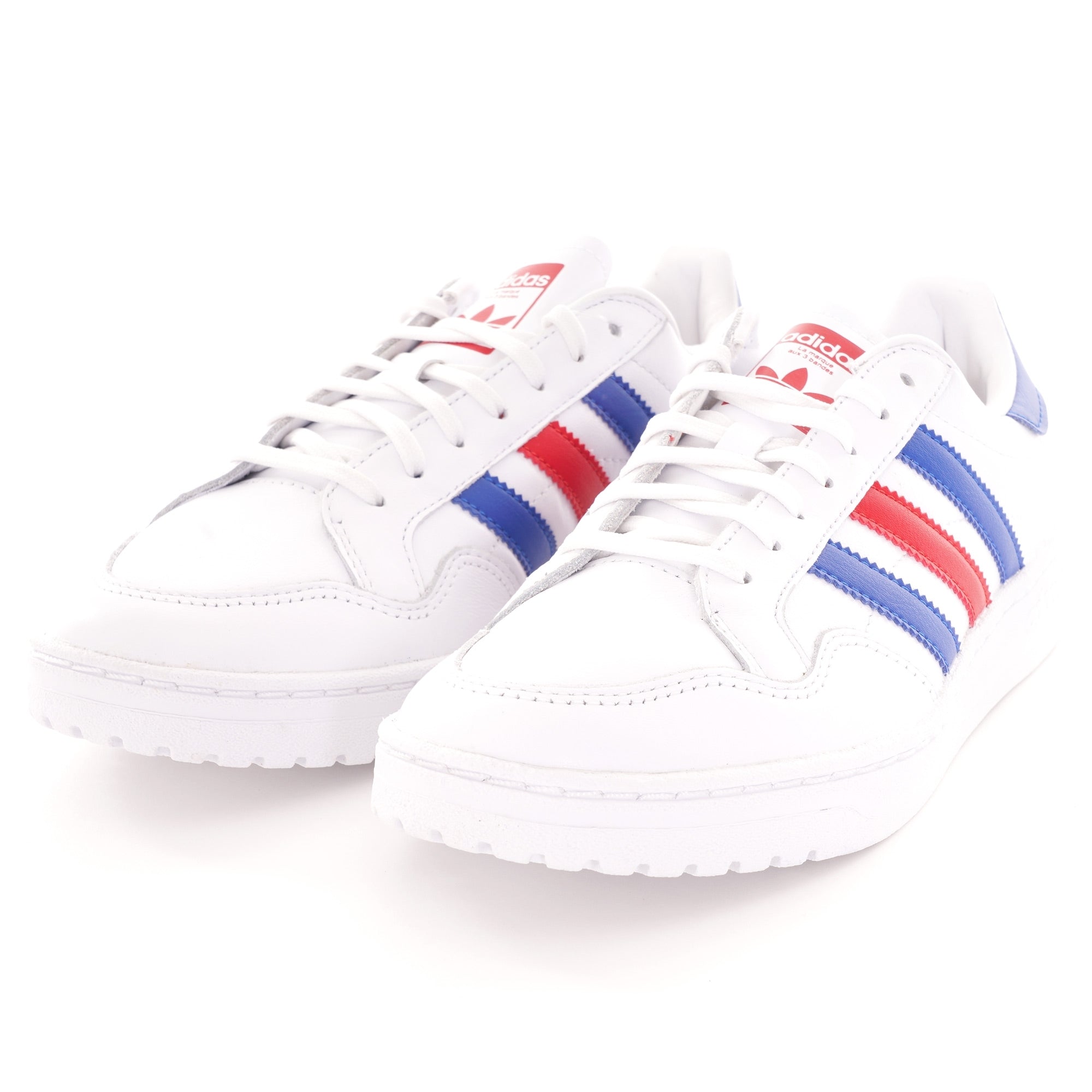 A close-up, high-angle, side profile of two white Adidas trainers with blue and red stripes.
