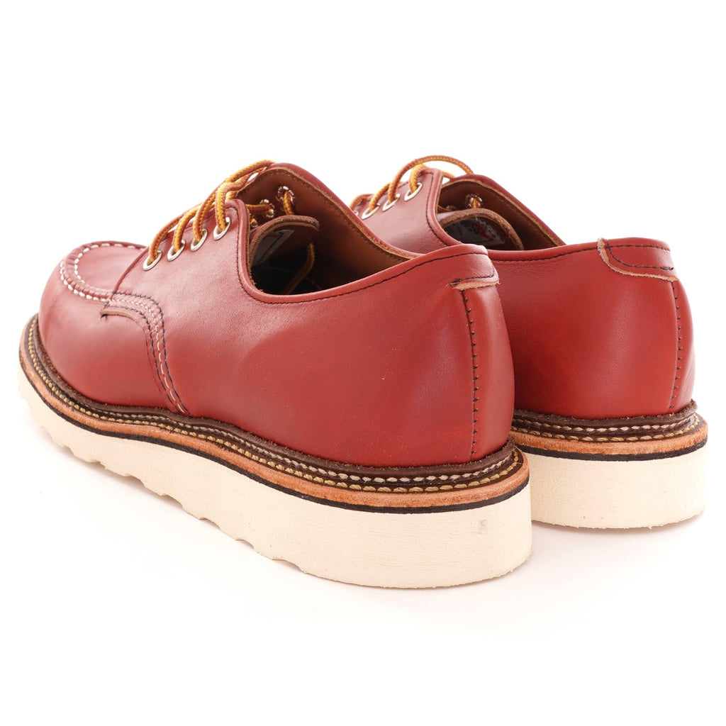 A pair of Red Wing Postman Oxford shoes in Oro Russet, with yellow laces, viewed from behind.