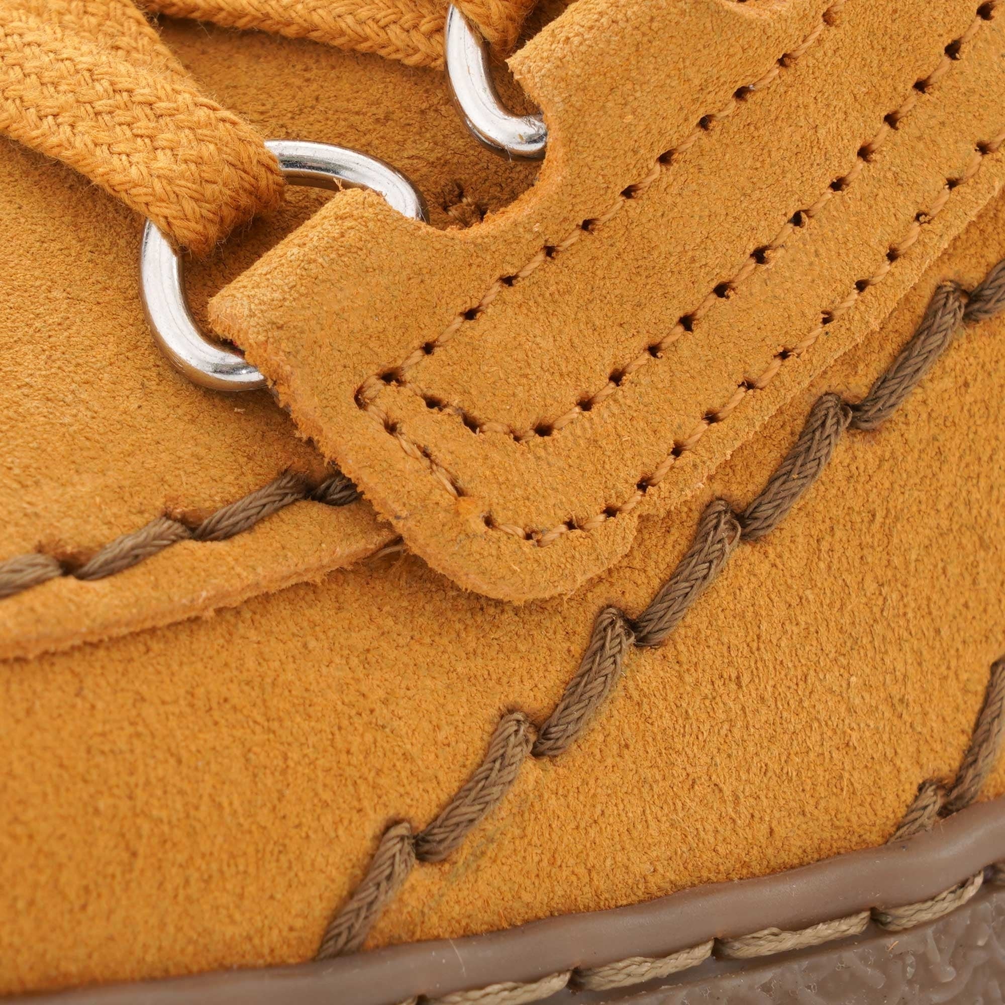 Close-up of the lacing and stitching details on a mustard yellow Mephisto 'Rainbow' shoe.