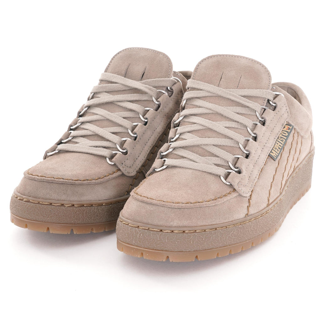 A pair of beige suede shoes with light coloured laces and thick soles, viewed from an angle.