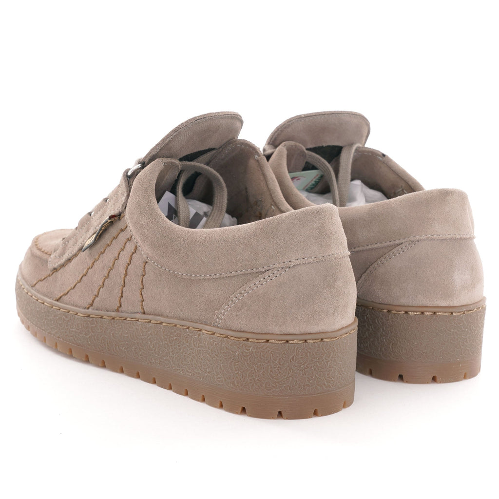 A pair of beige suede shoes with thick soles, viewed from the rear.