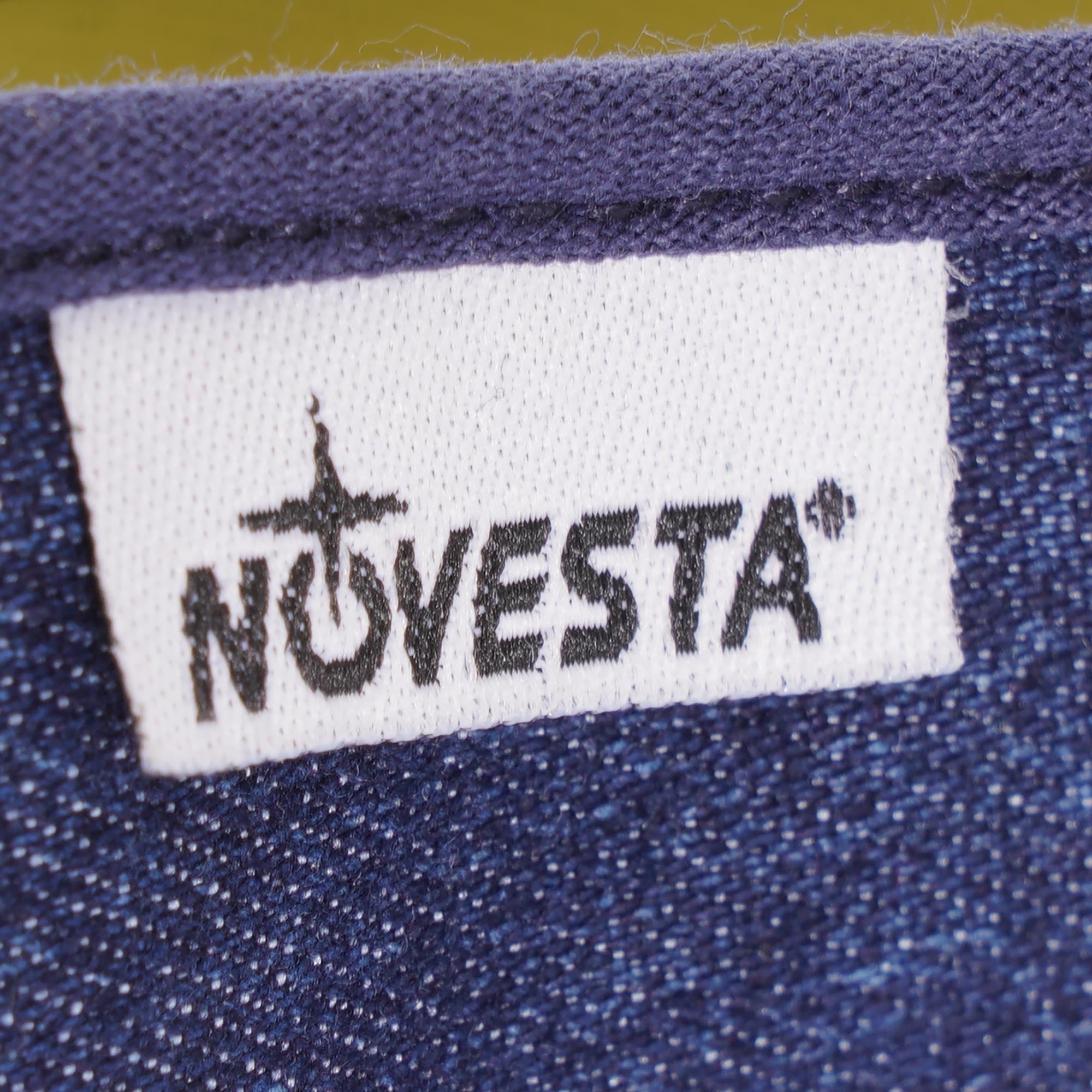 A close-up of the Novesta brand label on the side of a navy sneaker.