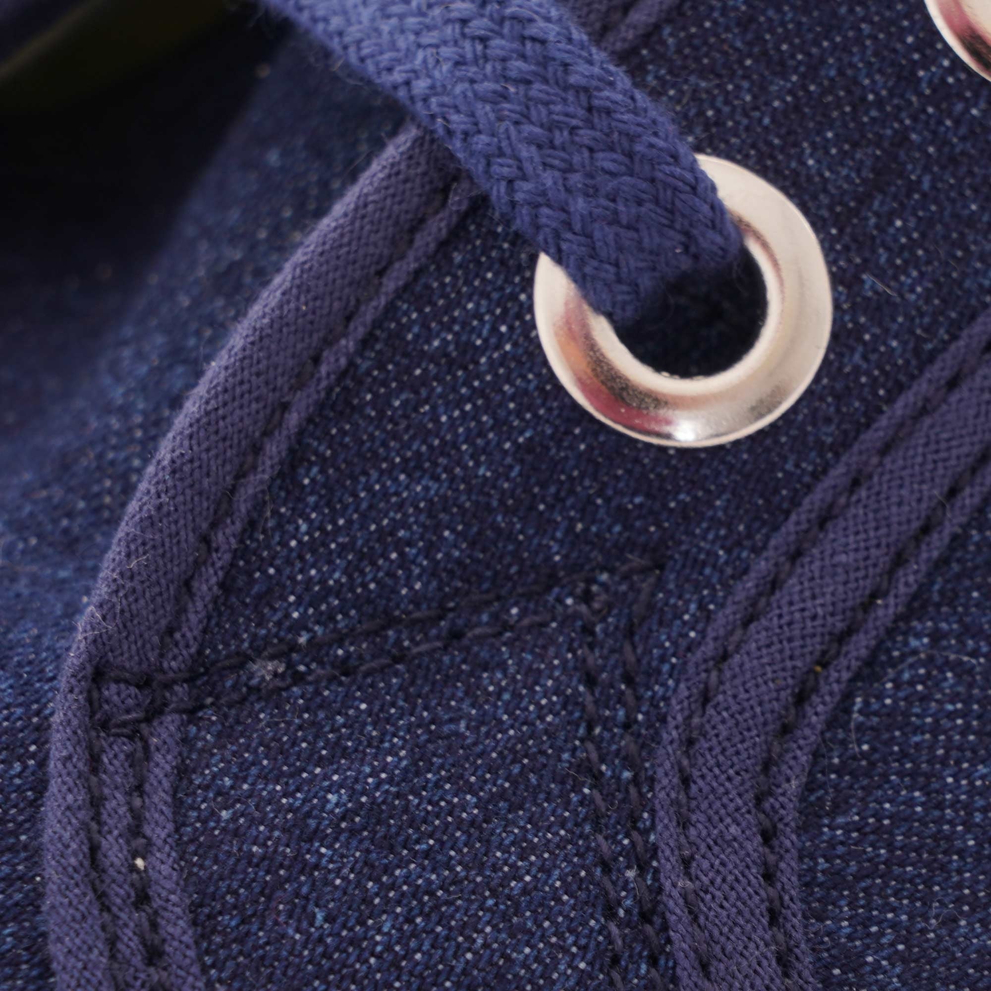 A close-up of the navy laces and metal eyelets on a Novesta Star Master sneaker.