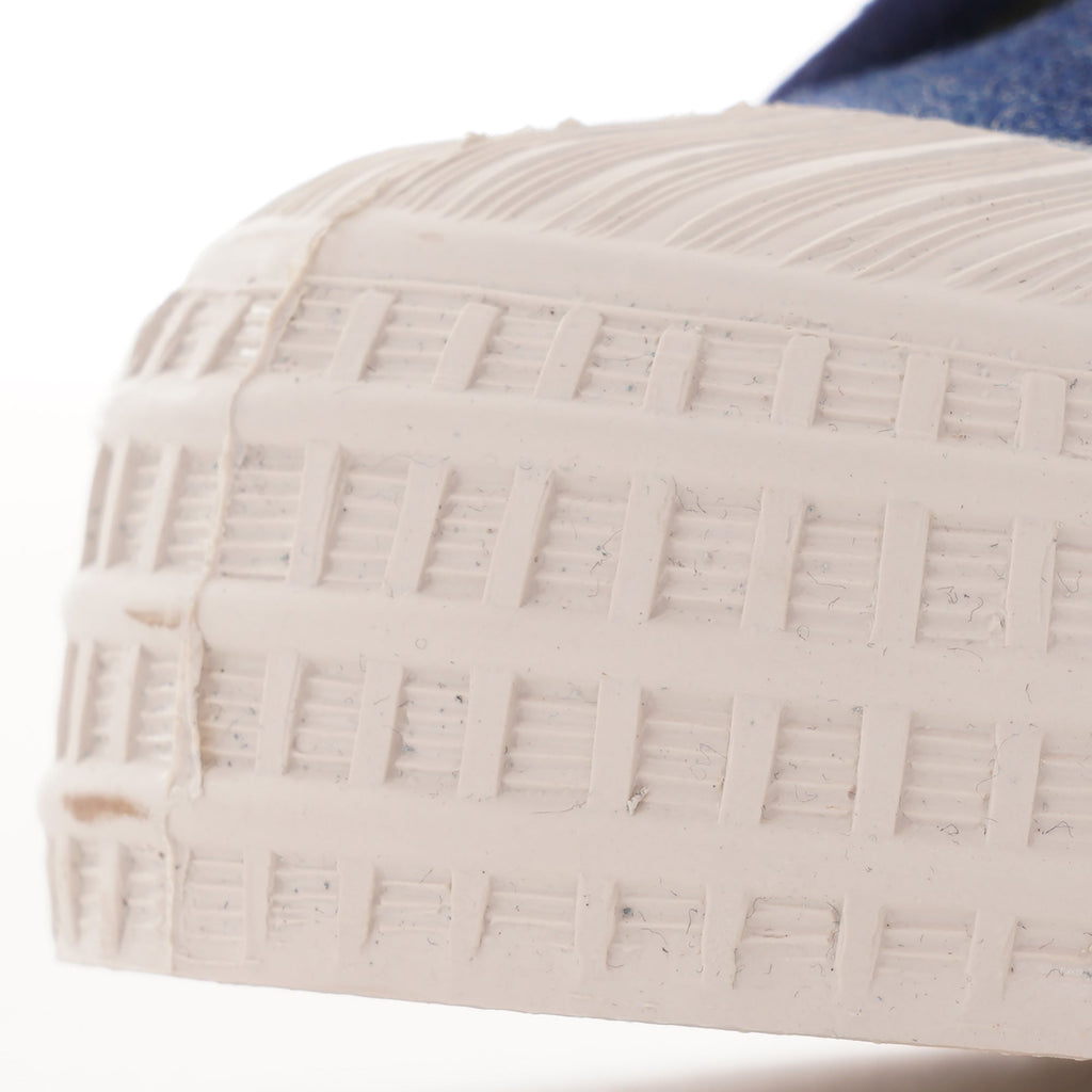 Close-up of the textured white rubber toe cap and sole of the shoe.