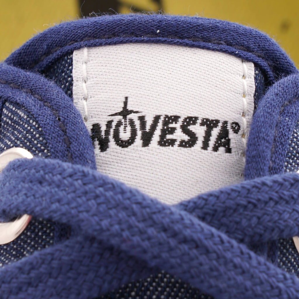 Close-up of the Novesta brand logo on the tongue of the navy blue shoe.