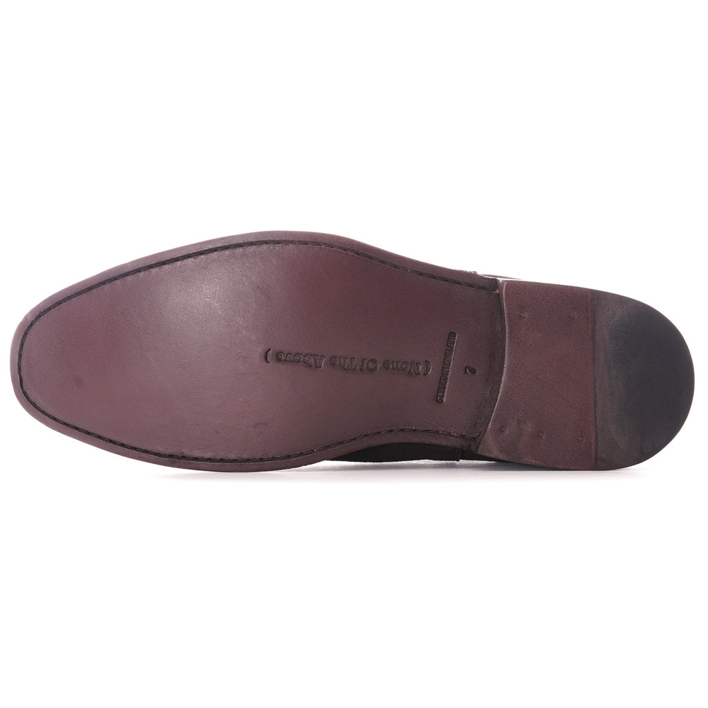 Sole of a brown suede Chelsea boot with embossed branding.
