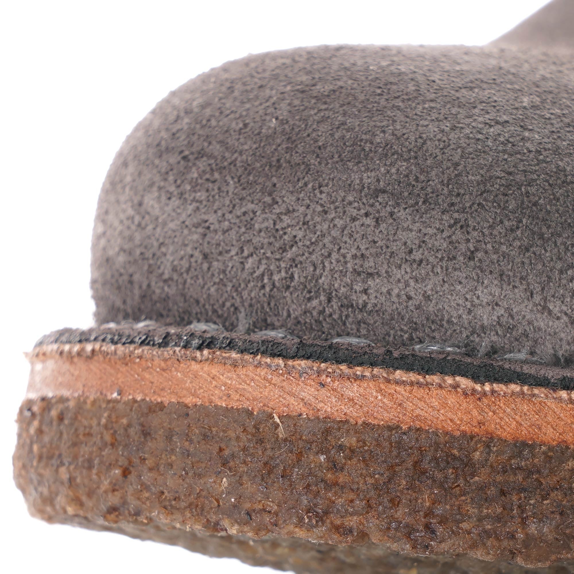 Close-up of the grey suede upper and brown sole of a desert boot.