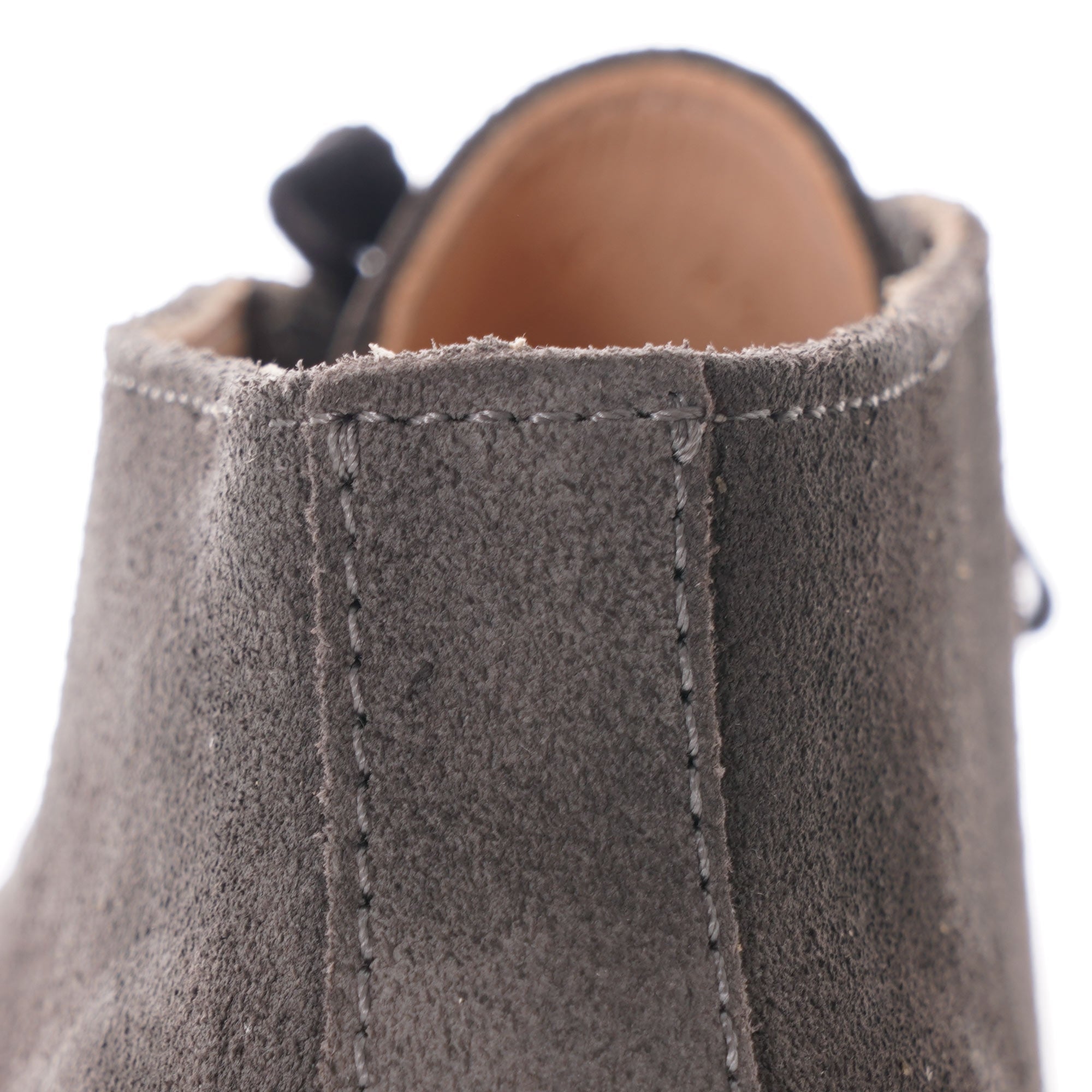 Close-up of the back stitching detail on a grey suede desert boot.