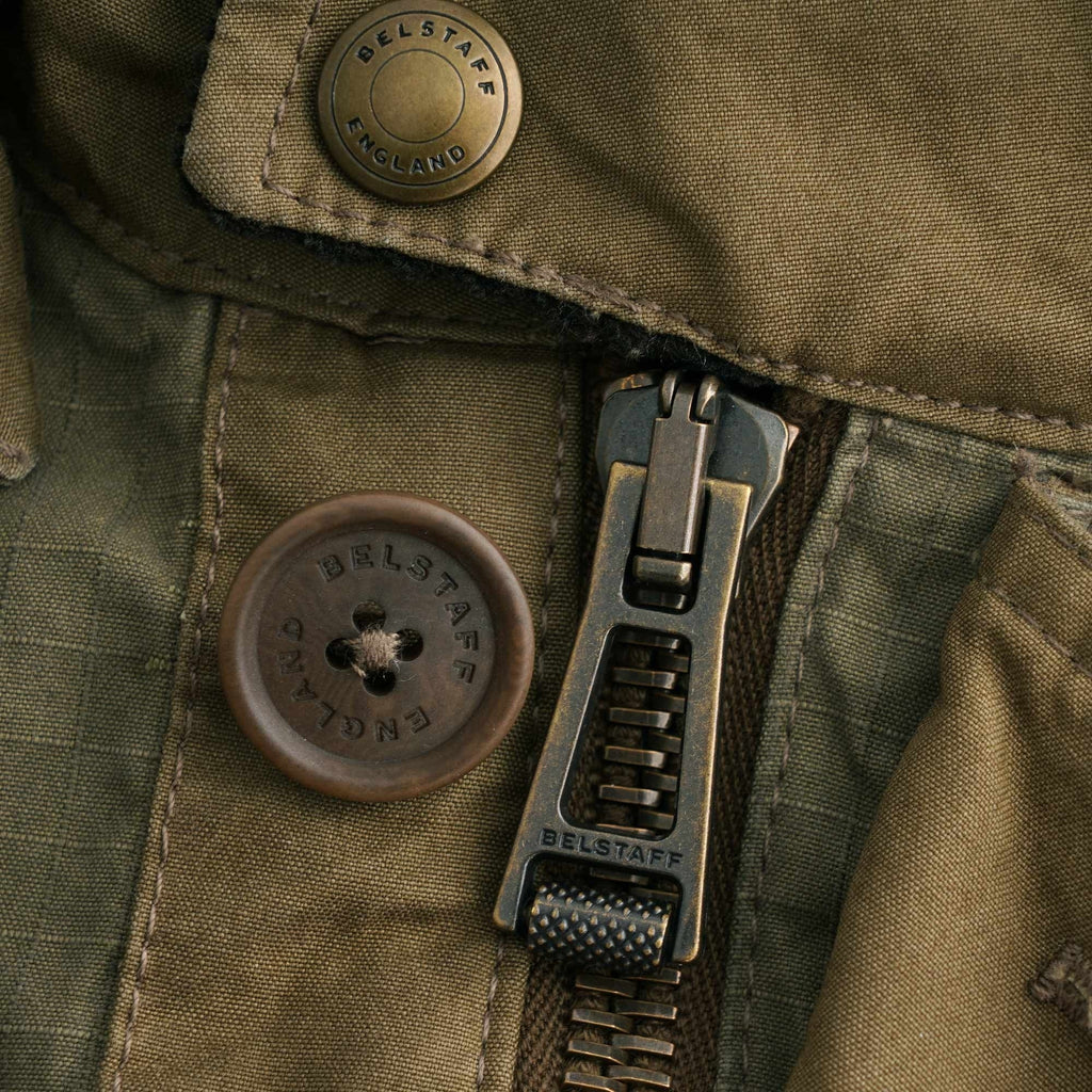 Close-up of the robust metal zipper and branded button on the Belstaff Fieldmaster Jacket.
