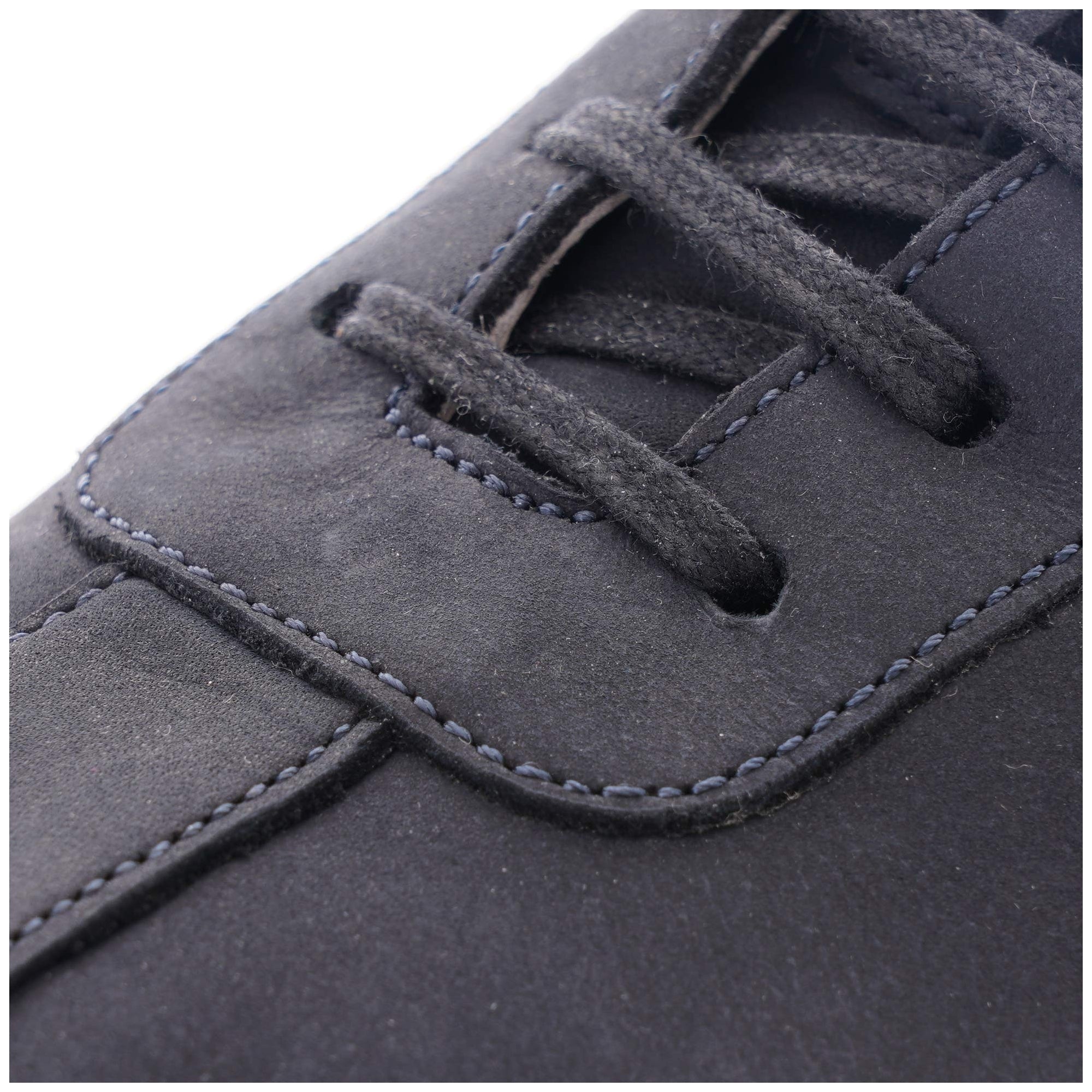 Close-up of the dark blue laces and stitching on a stylish casual shoe.