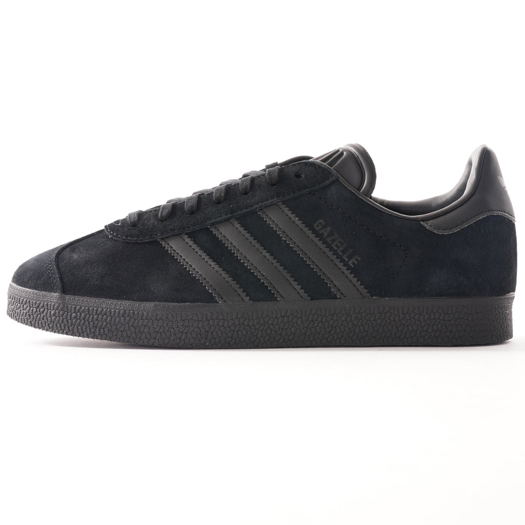A single black Adidas Gazelle trainer, photographed from the side.