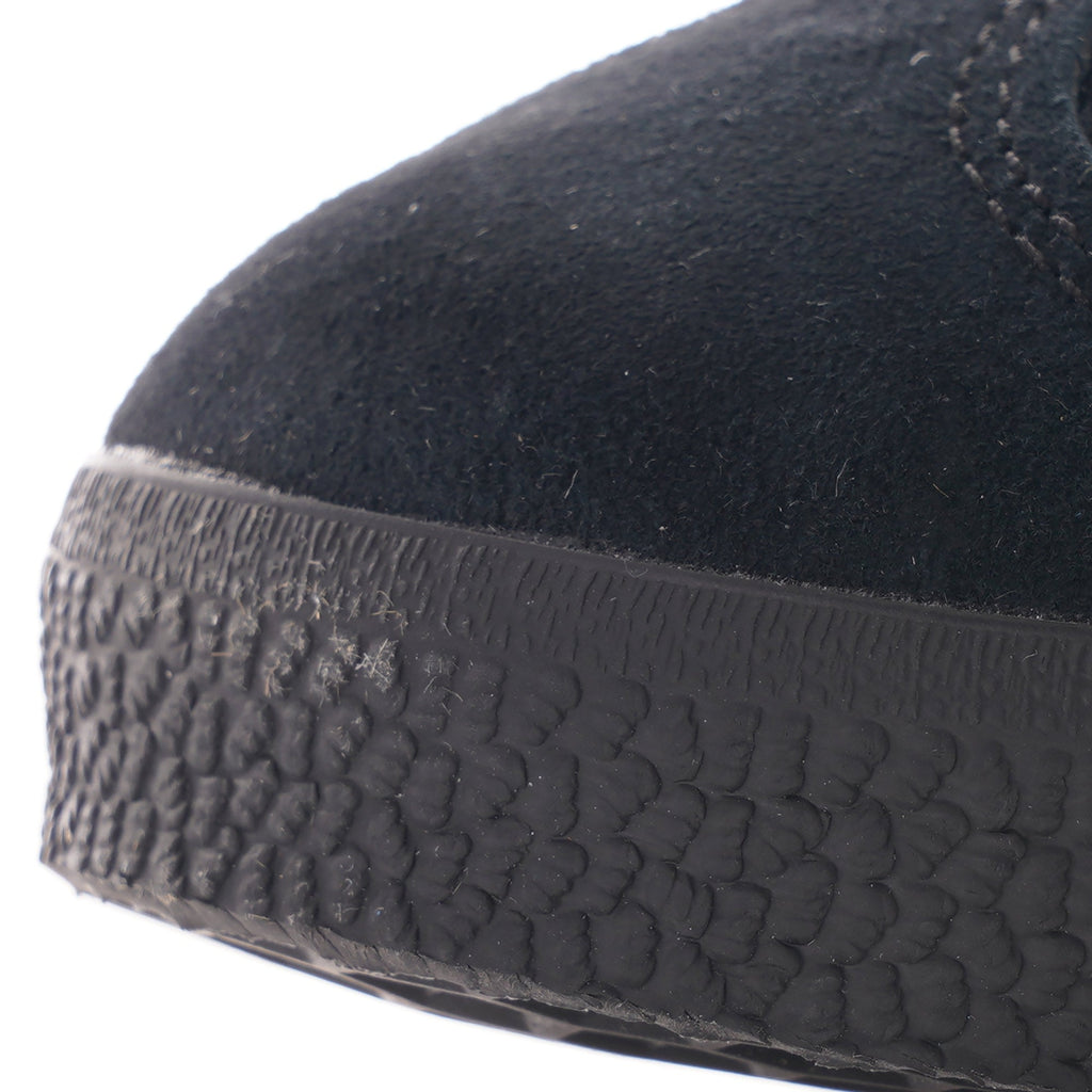 A close-up of the toe of a black Adidas Gazelle trainer, showing the textured sole.