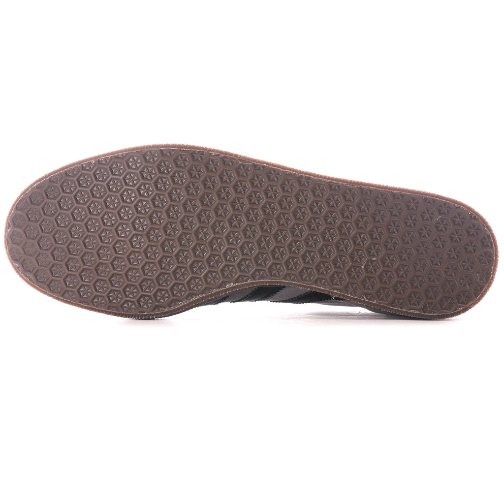 The textured brown sole of a grey Adidas Gazelle trainer, viewed from directly underneath.