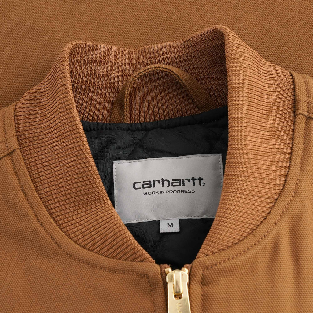 Close-up of the Carhartt WIP label on the collar of the brown vest, showing size M.