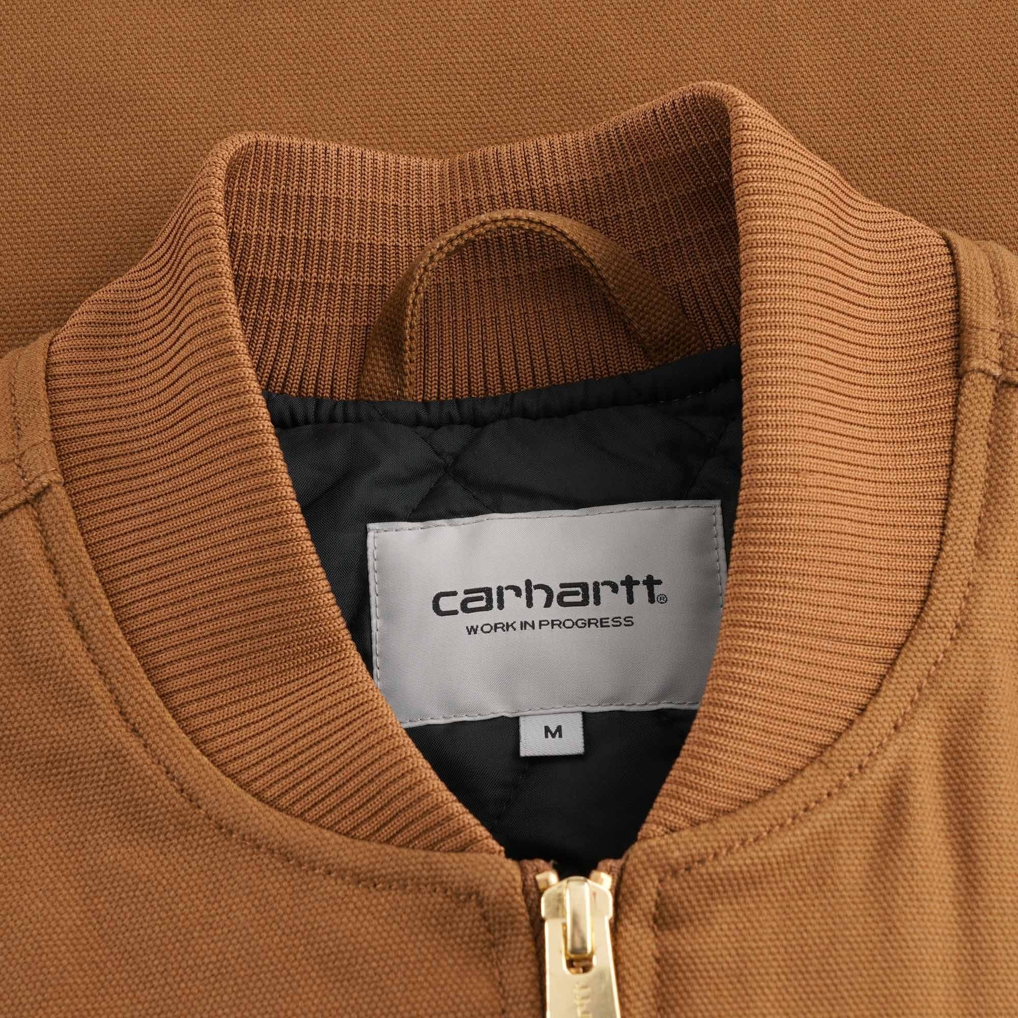 Close-up of the Carhartt WIP label on the collar of the brown vest, showing size M.