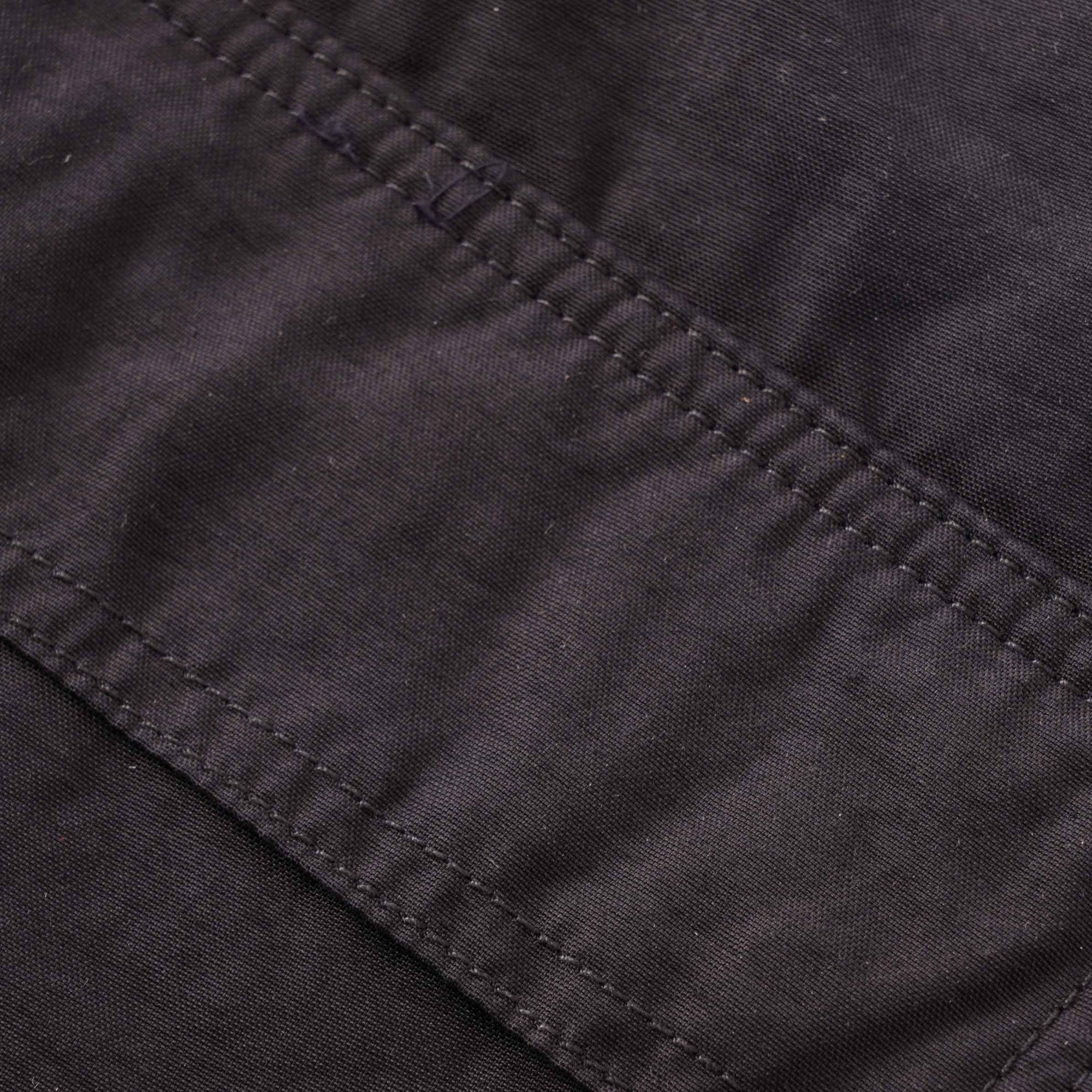 A close-up of the textured fabric and stitching on the dark grey cargo trousers.