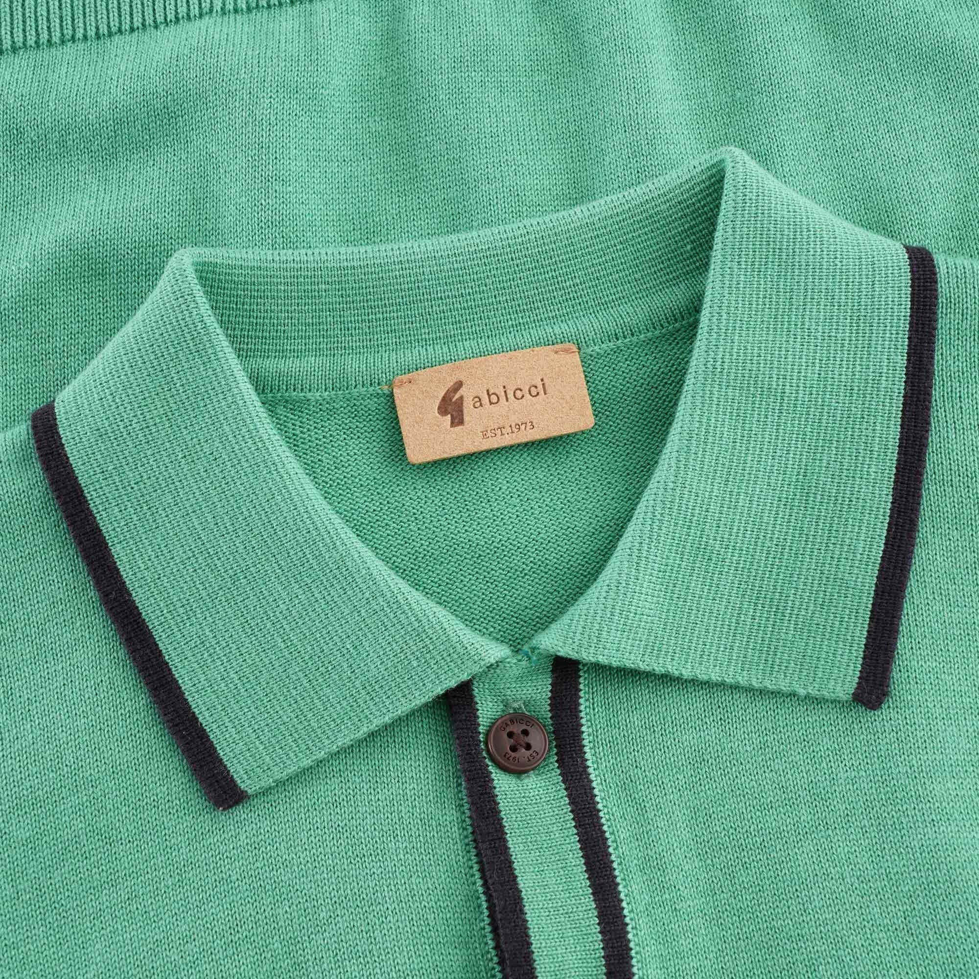 A close-up of the collar and neck label of the green knitted polo shirt.