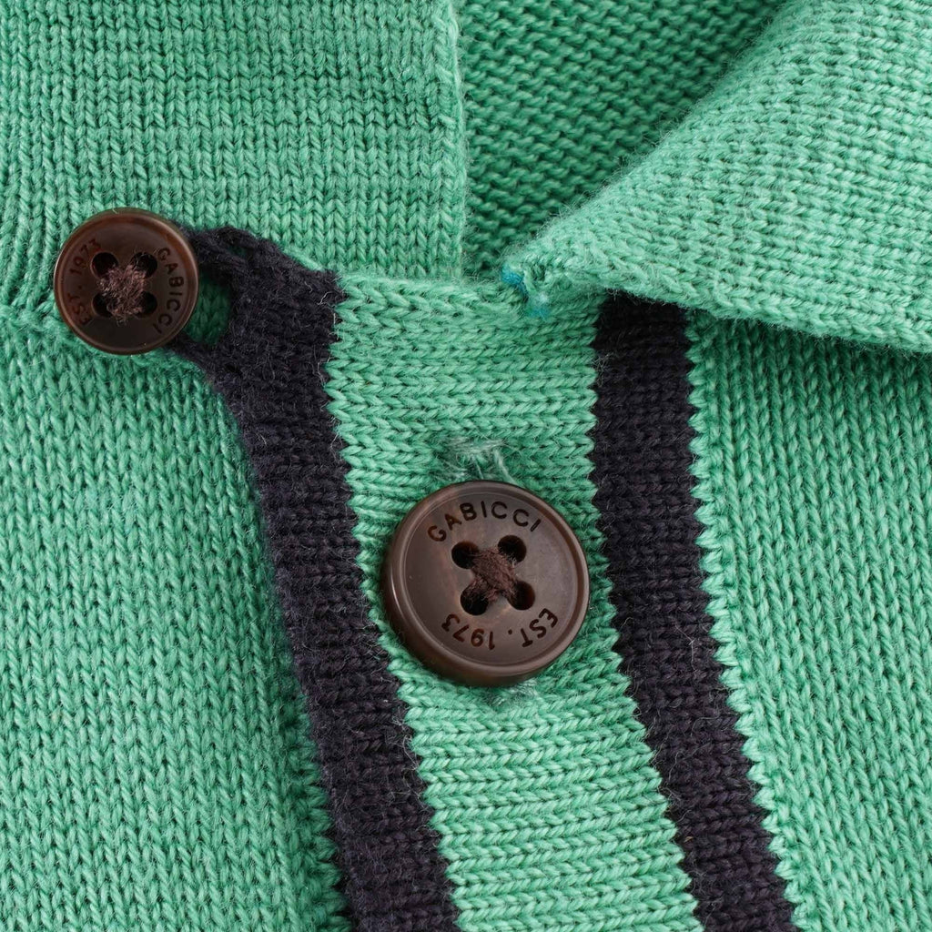 A close-up of the buttons on the green knitted polo shirt.