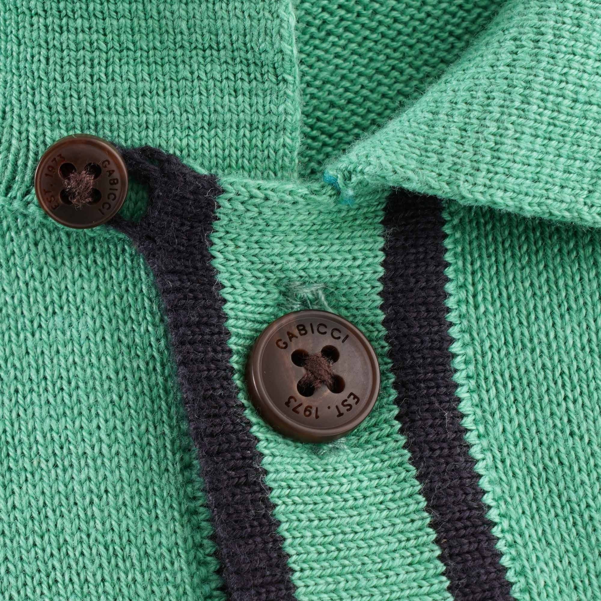 A close-up of the buttons on the green knitted polo shirt.
