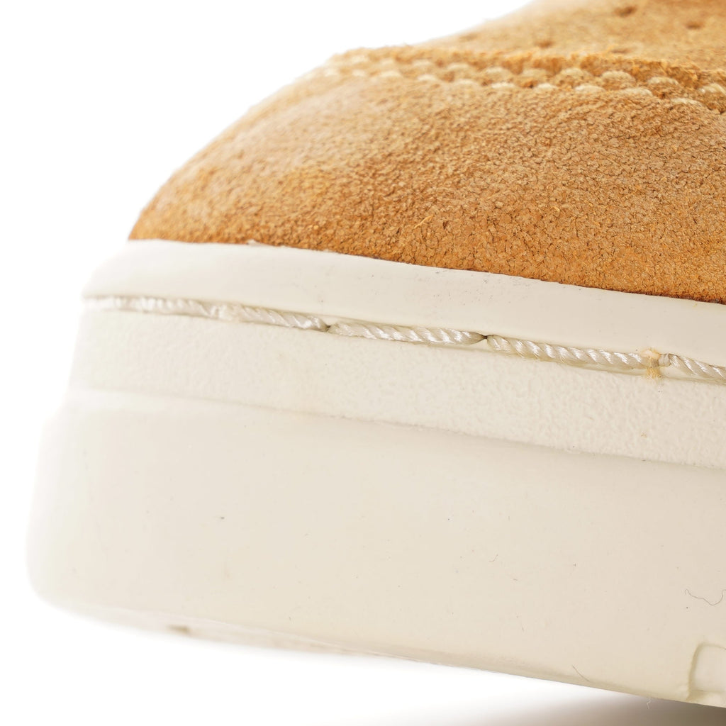 Close-up of the textured cream sole and tan suede upper of an Autry Medalist Low.