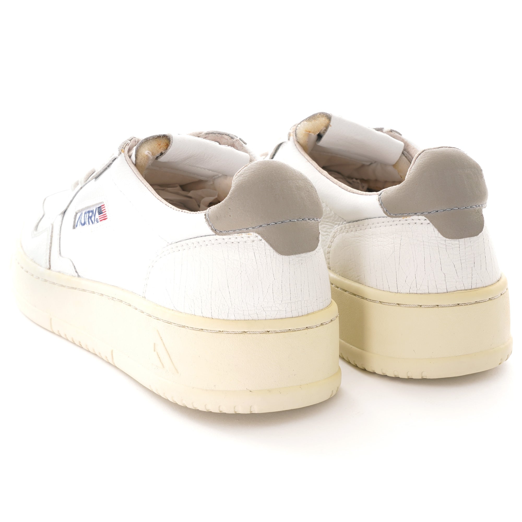 A pair of white Autry Medalist trainers, rear three-quarter view, on a white background.
