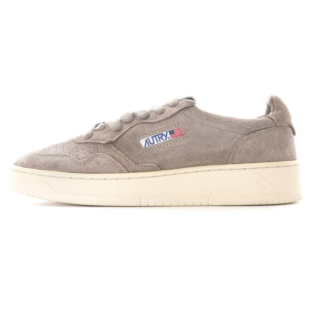 A single Autry Medalist Low sneaker in grey suede with a white sole, viewed from the side.