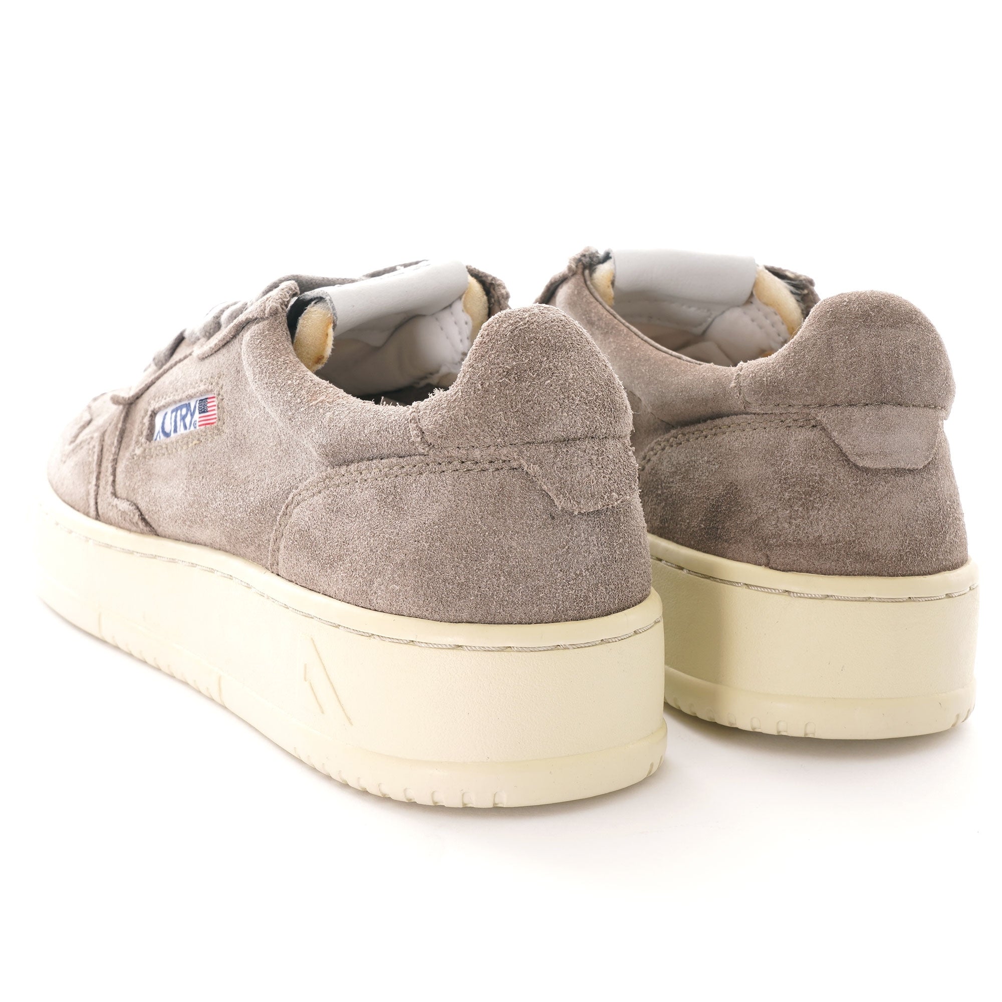 A pair of Autry Medalist Low sneakers in grey suede, with white soles, viewed from the rear.
